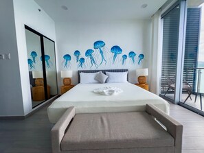 Un dormitorio moderno con una cama grande, una pared de cristal y un mural en el techo con medusas.
