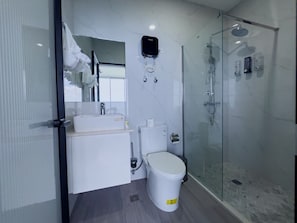 Ein modernes Badezimmer mit Duschkabine aus Glas, Toilette und Waschbecken.