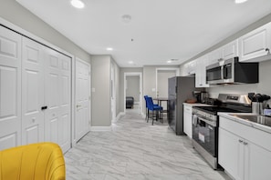 A modern kitchen with white cabinetry, a stainless steel refrigerator, and a built-in oven. - Private DC 2BR Suite Near Shaw + NoMa Metro, Downtown, Union Market + Howard U (Washington)