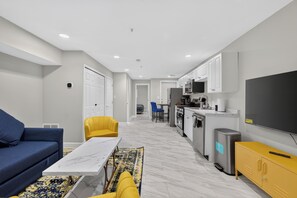 A modern living room with a sofa, a coffee table, and a TV. - Private DC 2BR Suite Near Shaw + NoMa Metro, Downtown, Union Market + Howard U (Washington)