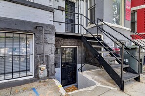 A building with a black metal staircase leading to a door, a window with a metal shutter, and a red banner advertising vacancies. - Private DC 2BR Suite Near Shaw + NoMa Metro, Downtown, Union Market + Howard U (Washington)