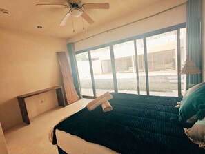 A bedroom with a bed, a ceiling fan, a window, and a view of the outdoors. - Peaceful Luxury Ground-Floor Retreat, 2BR, 2BA, Selva Norte Tulum (Tulum)