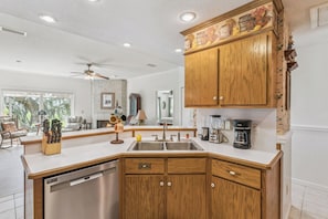 A kitchen with wooden cabinets, a dishwasher, and a coffee maker.