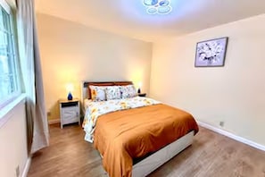A bedroom with a bed, bedside table, and a wall-mounted light fixture. - 686 Serene 2-bedroom house in San Jose for a relaxing stay (San Jose)