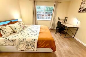 Ein Schlafzimmer mit einem Bett, einem Schreibtisch und einem Fenster.