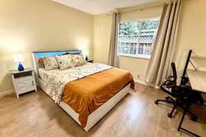 Ein Schlafzimmer mit einem Bett, einem Nachttisch, einem Schreibtisch und einem Stuhl.