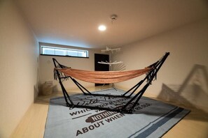 A hammock on a rug with motivational text, a window, and a ceiling light. - Biancolina (Fukuoka City)