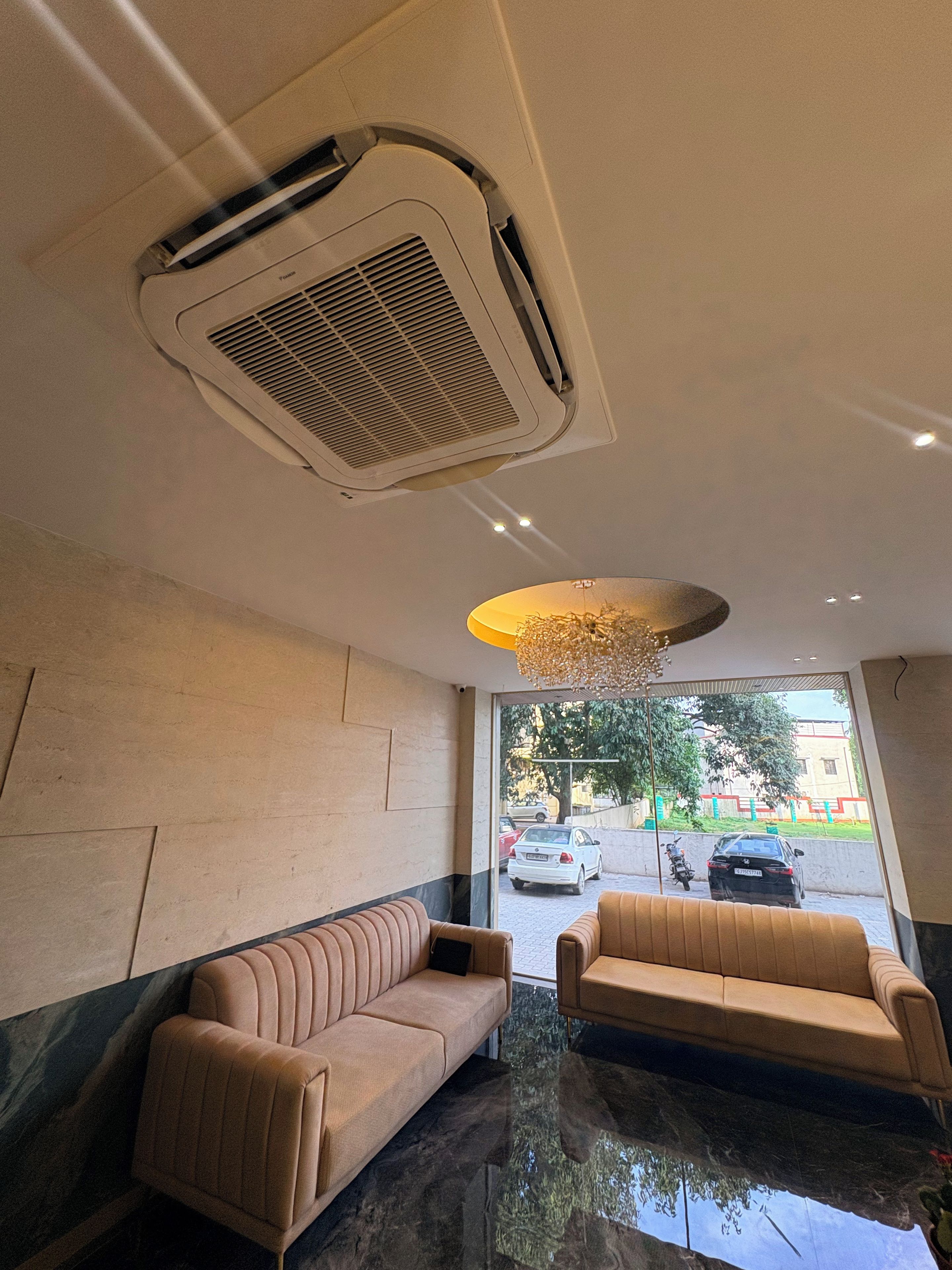 Un vestíbulo de hotel con zona de estar, un conducto de ventilación en el techo y vistas a la calle.