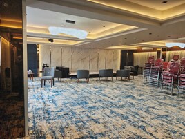 Une chambre d’hôtel avec un grand lit, un bureau et une chaise. Il y a une fenêtre avec des rideaux et une vue sur l’extérieur.