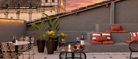 An outdoor seating area with a view of a historic building, featuring a mix of modern and traditional furniture.