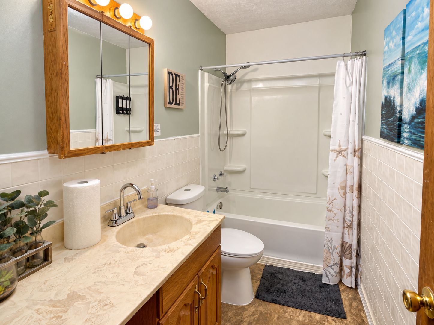 Une salle de bain avec un lavabo, des toilettes et une douche.