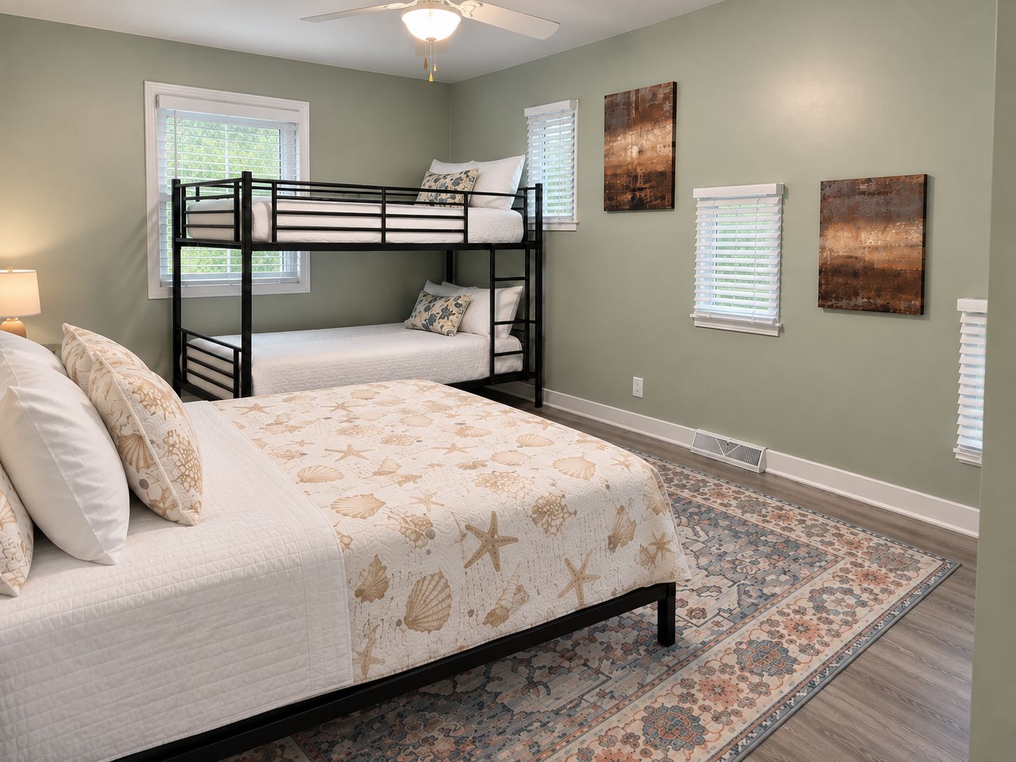 A bedroom with bunk beds, a patterned bedspread, and a decorative rug.