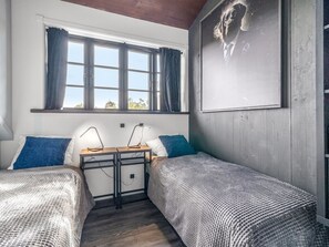 A room with two single beds, a desk with two lamps, a window with curtains, and a wall-mounted artwork. - "Geeske" - 1.1km from the sea by Interhome (Ebeltoft)