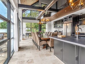 A modern kitchen with a dining area, large windows, and a view of the outdoors. - "Geeske" - 1.1km from the sea by Interhome (Ebeltoft)