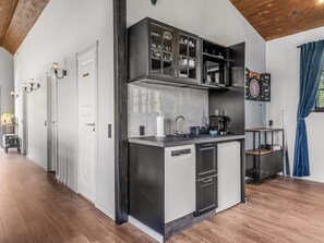 Een kleine keuken met een vaatwasser, een magnetron en een koffieapparaat.