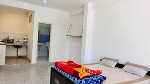 A bedroom with a bed, a bedside table, and a bathroom visible through an open door.