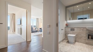 Ein modernes Badezimmer mit Toilette, Waschbecken und Spiegel.
