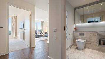 A modern bathroom with a toilet, sink, and mirror.