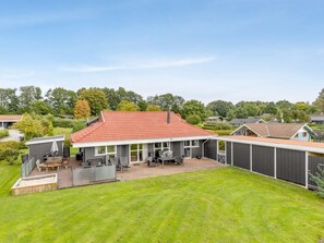 A residential property with a red-tiled roof, a patio with outdoor furniture, and a fenced backyard. - "Helrun" - 800m from the sea by Interhome (Hejls)