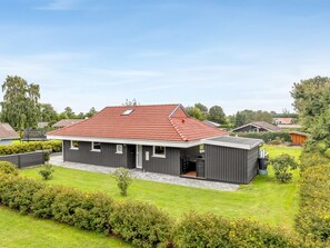 A modern two-story house with a red-tiled roof, grey siding, and a well-maintained lawn. - "Helrun" - 800m from the sea by Interhome (Hejls)