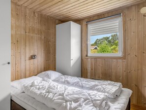 A bedroom with a bed, a wardrobe, and a window with a view of greenery. - "Helrun" - 800m from the sea by Interhome (Hejls)