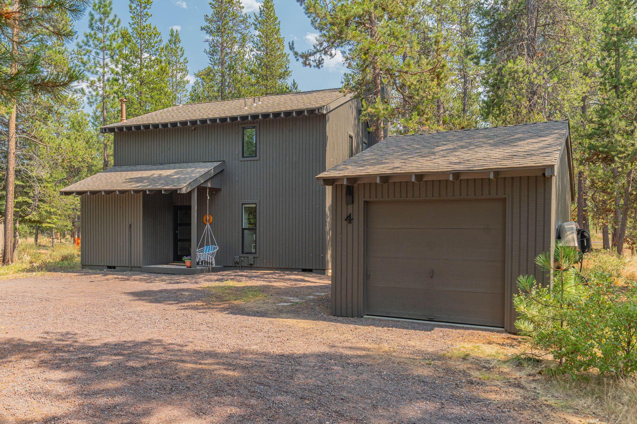 A two-story building with a garage and a covered porch.
