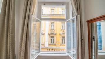 A room with a window overlooking a building labeled 'RESTAURANT' and a radiator below.