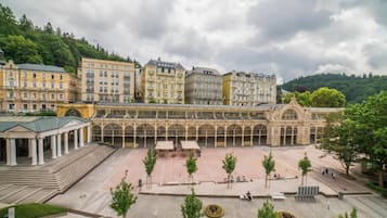 A spacious courtyard with a central open area, surrounded by classical architecture and trees.