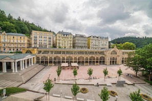 A spacious courtyard with a central open area, surrounded by classical architecture and trees.