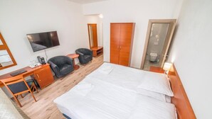 A hotel room with a bed, a desk, a chair, a television, a wardrobe, and a bathroom. - Mariánské Lázně Colonnade - Room in the centre (Mariánské Lázně)