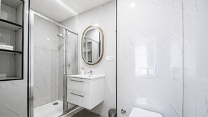 A modern bathroom with a glass shower enclosure, a white sink with a gold-rimmed mirror, and a toilet. - Mariánské Lázně Colonnade - Room in the centre (Mariánské Lázně)