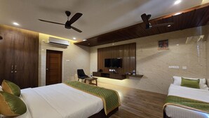 Une chambre d’hôtel avec deux lits, une télévision, un bureau et une chaise.