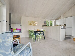 A room with a dining area, a sofa, and a kitchen. - "Heidrun" - 400m from the sea by Interhome (Væggerløse)