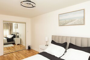 Ein Hotelzimmer mit Bett, Nachttisch, Lampe und einem Bild an der Wand.