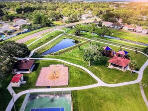 Vista aérea de uma área residencial com parquinho, piscina e quadra de tênis.