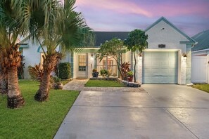 Stunning Florida Home! This beautifully lit single-level oasis offers keyless entry & 3 off-street parking spaces (1 garage + 2 driveway). Features iconic coastal curb appeal w/ lush palms, tropical landscaping, blue trim & gorgeous sunset lighting! - Waterfront ~ Heated Saltwater Pool ~ 8 mi to Beach (Largo)