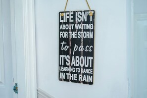 Een inspirerend bord met een verweerde uitstraling, aan een witte muur bevestigd.