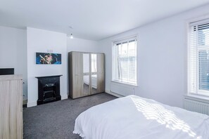 Ein Schlafzimmer mit Bett, Kleiderschrank und Kamin.