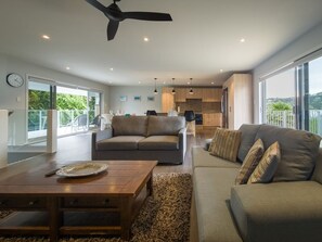A modern living room with a sofa, coffee table, and a ceiling fan.