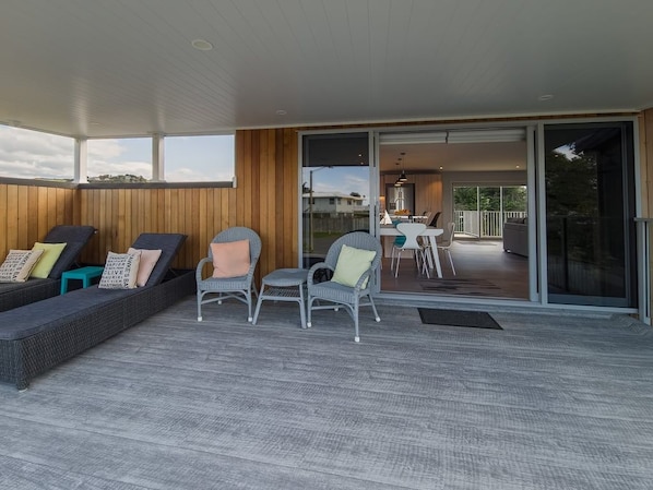 An open-plan living area with a sofa set, chairs, and a dining table.