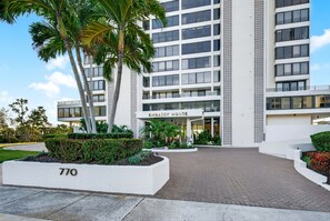 A modern building with a sign reading 'Embassy House' at the entrance, surrounded by well-maintained landscaping and palm trees. - Downtown Sarasota Penthouse with Post card waterfront views (Sarasota)