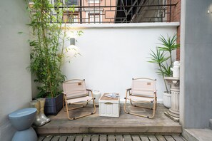 A small outdoor seating area with two chairs, a table, and potted plants. - Tonighy Homestay Jing'an Temple Shanghai (Shanghai)