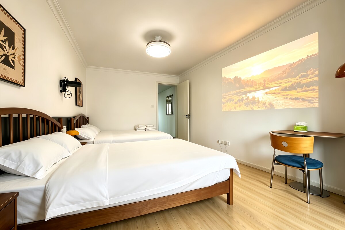 A hotel room with a bed, bedside table, lamp, and a large window with a scenic view.