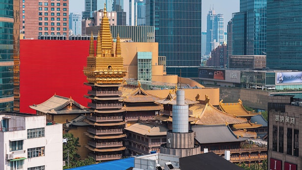 A traditional pagoda with multiple tiers and golden accents, surrounded by modern high-rise buildings. - Tonighy Homestay Jing'an Temple Shanghai (Shanghai)