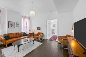 A modern living room with a sofa, armchair, coffee table, and a flat-screen TV. - Second Floor, Spacious, 1 Bd Apartment Near Barnes - Stay Smiley Rentals (St. Louis)