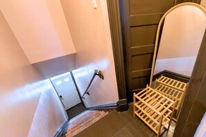 A narrow stairway with a metal handrail, a wooden rack, and a door at the top. - Second Floor, Spacious, 1 Bd Apartment Near Barnes - Stay Smiley Rentals (St. Louis)