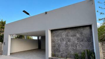 A modern building with a flat roof, a large garage door, and a stone facade.