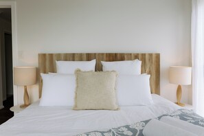 A hotel room with a bed, two bedside lamps, and a wooden headboard. - Oracle Beach House @ Penneshaw, Kangaroo Island (Penneshaw)