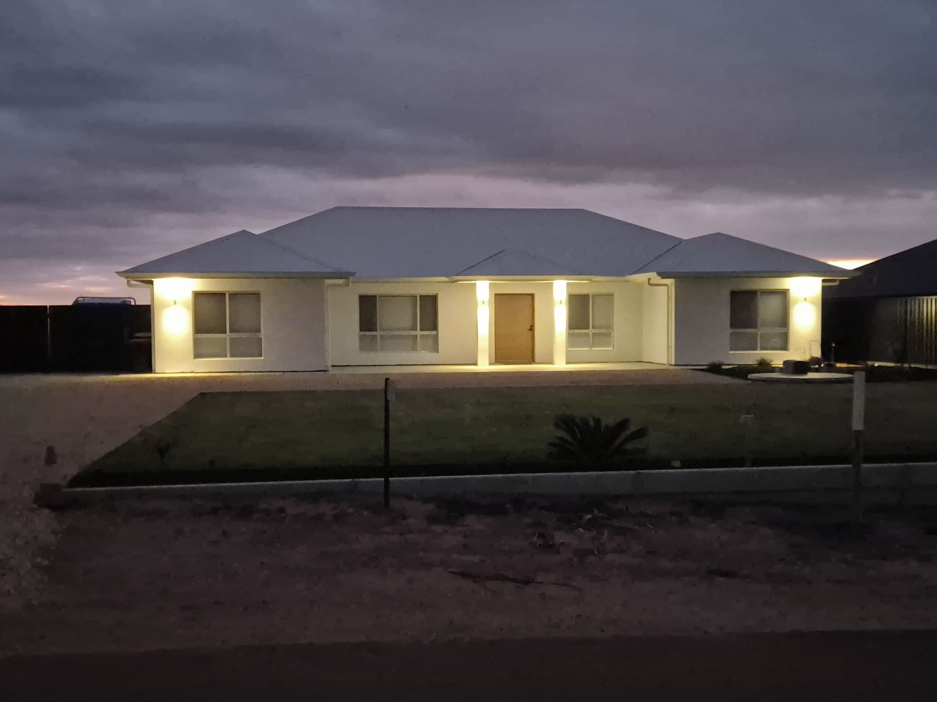 A two-story house with a flat roof, multiple windows, and a front door.