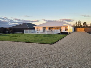 A house with a covered patio, a fenced yard, and a gravel driveway. - Paringa Escape (Paringa)
